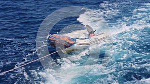 Floating lifeboat tied to pleasure yacht concept for rescue operations and maritime safety
