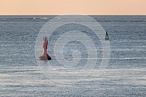 Floating navigational buoy floating in a calm sea in Norderney, Germany