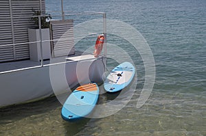 A floating pier floating with two surfboards tied in the water