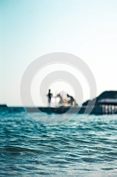 Floating platform in the sea, with teenagers having fun, out of focus