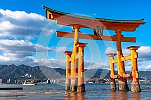 Floating red giant Grand O-Torii gate stands in Miyajima island bay beach