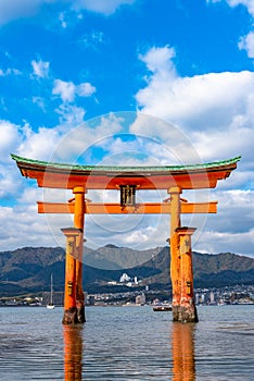 Floating red giant Grand O-Torii gate stands in Miyajima island bay beach