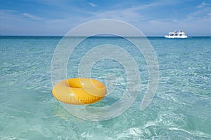 Floating ring on blue clear sea with white boat