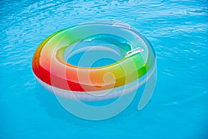 Floating ring on blue water pool with waves reflecting in the summer. Blue aqua textured background.