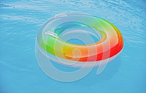 Floating ring on blue water pool with waves reflecting in the summer. Blue aqua textured background.