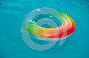 Floating ring on blue water pool with waves reflecting in the summer. Blue aqua textured background.