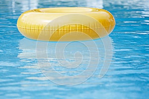 Floating ring on blue water swimpool with waves reflecting
