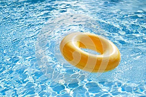 Floating ring on blue water swimpool with waves reflecting