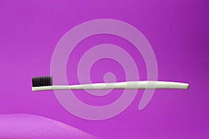 Floating toothbrush on pink background