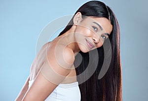 Floating on waves of great hair. Studio portrait of a beautiful young woman showing off her long silky hair against a