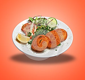 Floating White plate with three Cheese croquettes ans salad