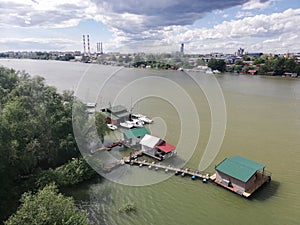 Floating wooden houses with boats on the river Sava in Belgrade, Serbia. View from the new Ada bridge.