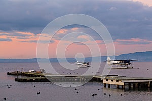 Floatplanes on a lake at dusk