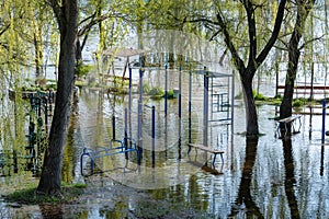 Flood on bank river in spring time. Water filled play and sport grounds in city.