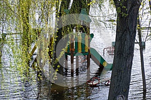 Flood on bank river in spring time. Water filled play and sport grounds in city.