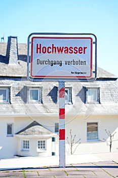 Flood high tide notice info sign on the sidewalk blocked, as a warning info board in German, German language
