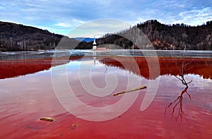 A flooded church in a toxic red lake