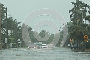Flooded road with cars passing through during hurricane Nicole in Palm Beach, Florida. November 2022