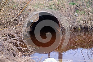 Flooded round sewer pipe with dirty water