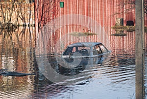 Flooded during the spring disaster to the roof car before the gates of a private house. High water in river flow freshet flood photo