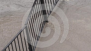 Flooded street in the cityFlood in the city. Water flows through a locked gate.