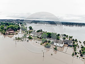 Flooded village on Ukraine. Natural disaster in Halych. Street with trees and houses in dirty river water photo