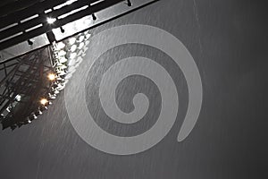 Floodlights in stadium above roof of stadium with pouring rain