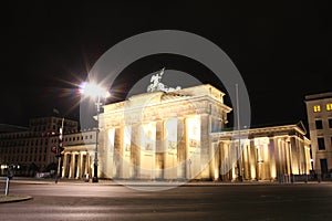 The floodlit Brandenburg Gate in Berlin with a few fleeting shad