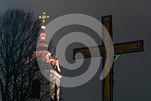 A floodlit church at night. Night photo of a Christian church. A cross on the background of the night sky