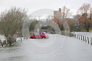 Floods engulf red car