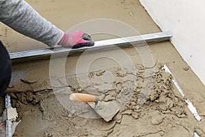 Floor construction - man leveling concrete screed photo