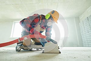 Builder at work. cutting concrete floor for cabling by diamond slitting machine photo