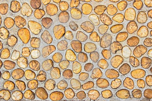 Floor gravel pebble stone on concrete wall background or fence texture made of a close up of medieval stone walls with colorful