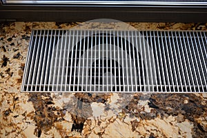 a floor heater grill and a marble floor, indoor closeup