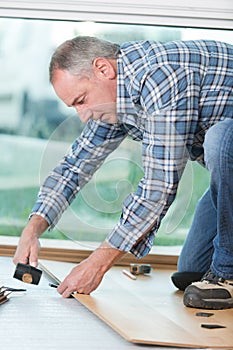 Floor installer using hammer