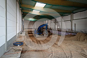 the floor of a newly built factory hall is excavated with an excavator