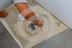 Floor preparation before pouring concrete in troweling adhesive onto a concrete floor