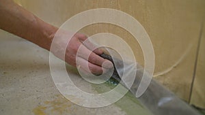 Floor repair. Worker glues special protection so as not to damage the baseboard