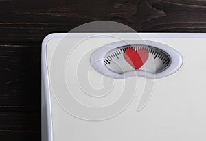 Floor scales with heart instead of numbers. Love your body concept. Fitness lifestyle motivation. Wooden background