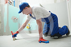 Floor waterproofing in bathroom. Worker adding Ãâ ater resistant, protective coating photo