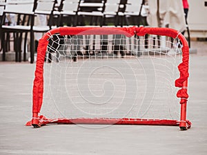 Floorball goal. Children playing outdoor in spring. Floor hockey players goalkeeper running with ball and sticks