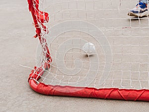 Floorball goal. Children playing outdoor in spring. Floor hockey players goalkeeper running with ball and sticks