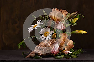 Floral arrangement with irises and daisies in a shell