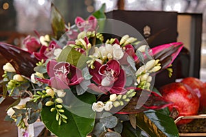 floral arrangement with orchids and pomegranates.