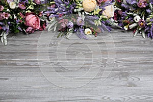 Floral arrangement on wooden texture background.