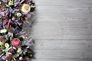 Floral arrangement on wooden texture background.