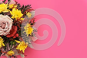 Floral arrangement, yellow chrysanthemum and pink rose in flower bouquet on pink background