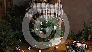 Floral artist creating Christmas flower composition.