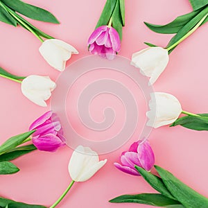 Floral background with tulips flowers on pink pastel background. Flat lay, top view. Spring time background.