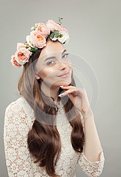Floral blossom portrait of beautiful young woman. Clear skin, long curly hair and flowers. Skincare and facial treatment concept